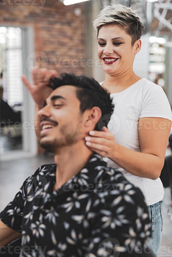 Professional hairdresser is cutting men's hair in beauty salon. photo