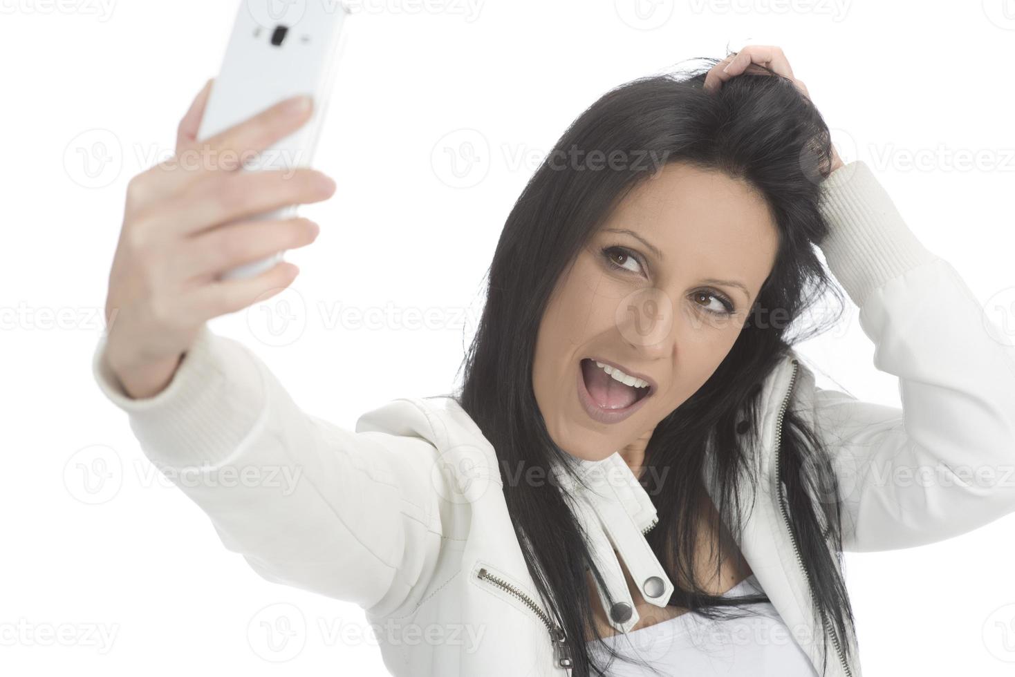 Image of beautiful brunette woman laughing while taking selfie photo on cellphone