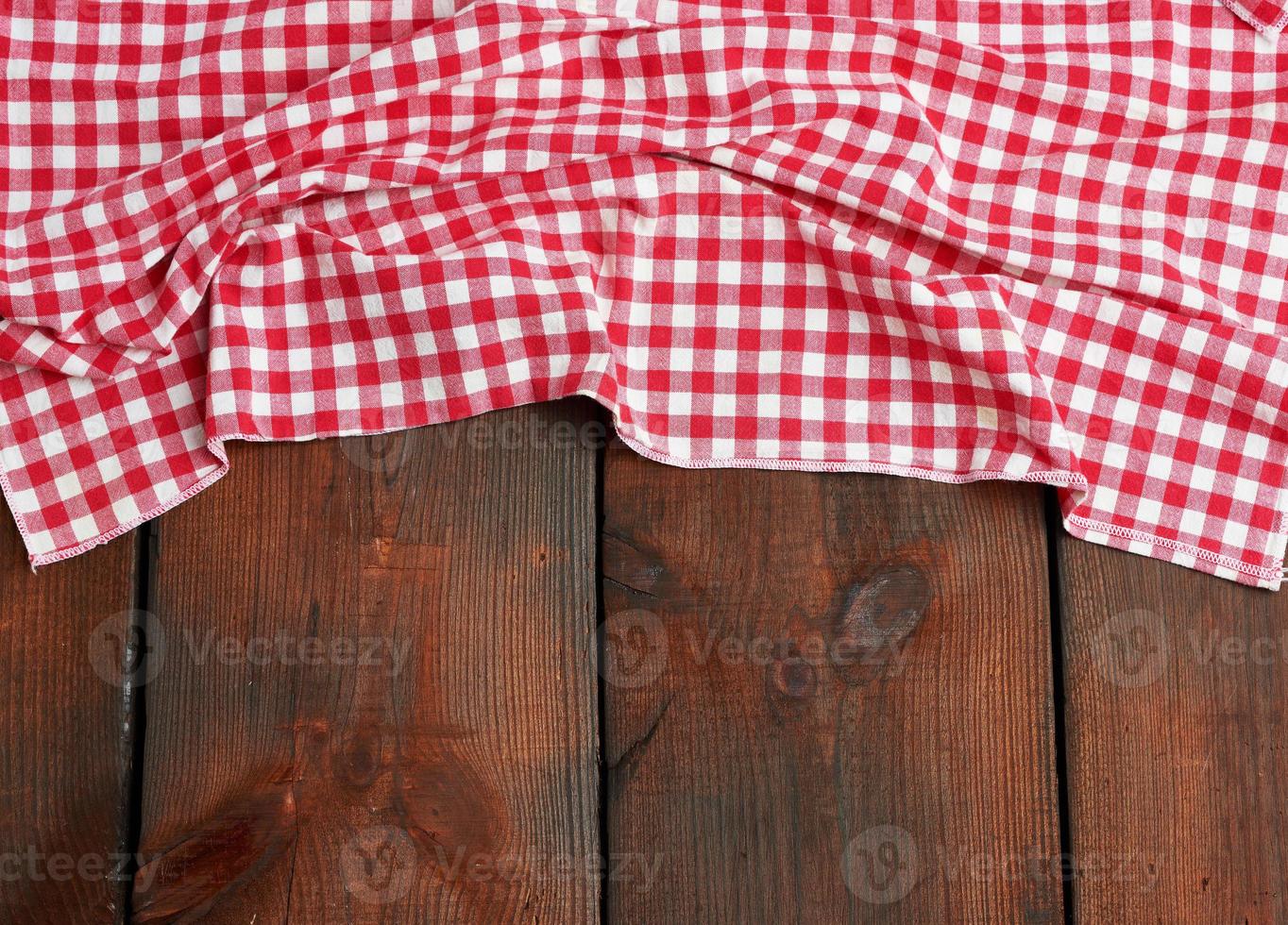 red-white textile kitchen towel on a brown wooden background from old boards, top view photo