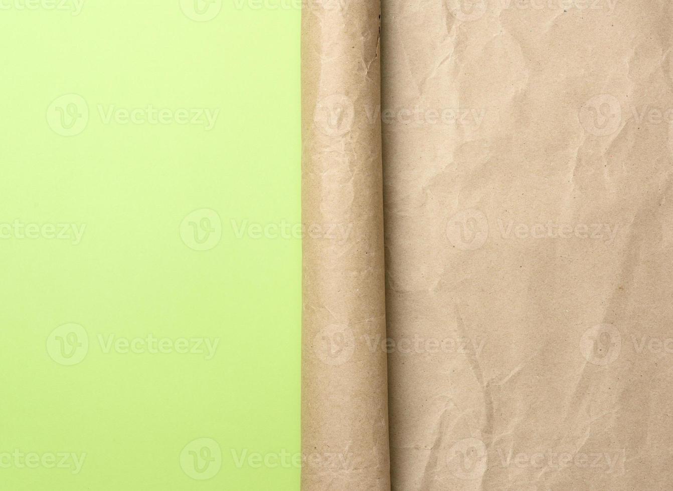folded corner of a roll of brown paper on a green background photo