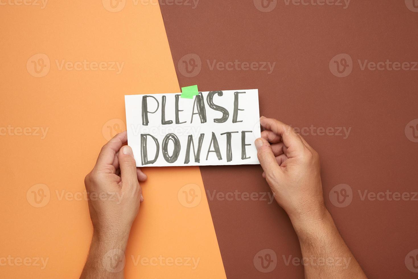 two male hands hold a sheet of paper with the inscription photo