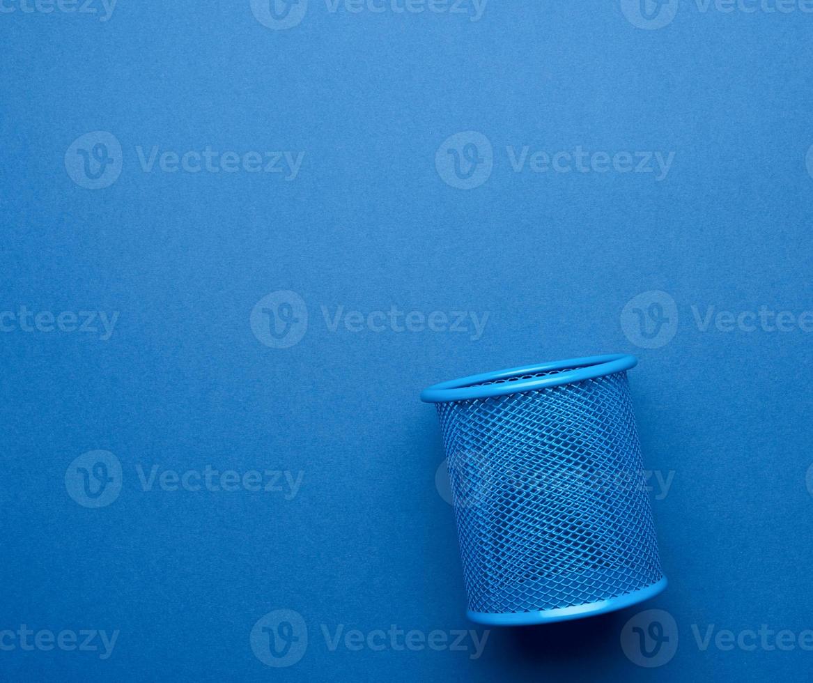 empty iron blue stationery basket for pens and pencils on blue background photo