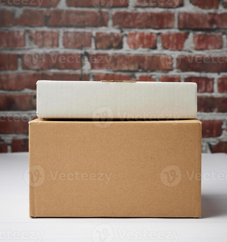 rectangular box made of brown corrugated cardboard on a brown brick wall background photo