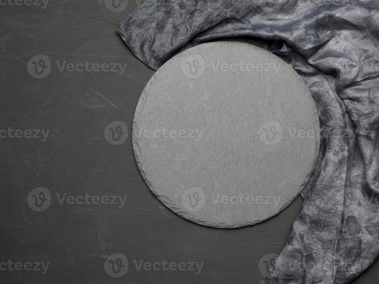 Blank round slate kitchen board on a black background photo