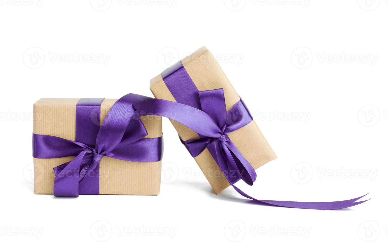 stack of wrapped boxes in brown kraft paper and tied with silk purple ribbon photo