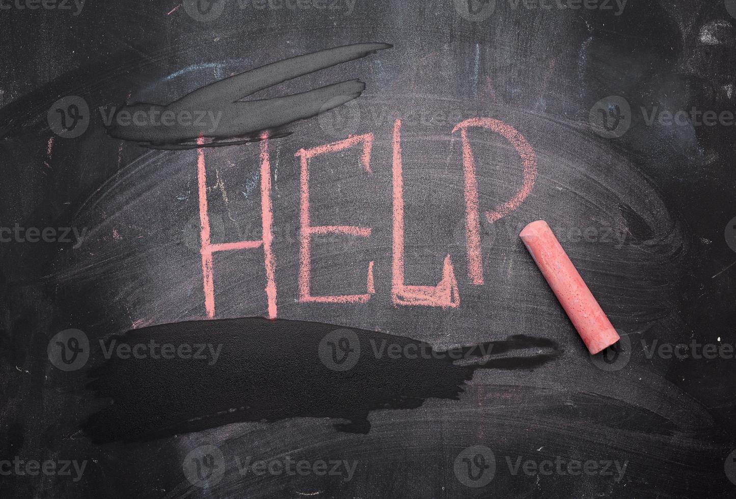 inscription help in red chalk on a black chalk board photo