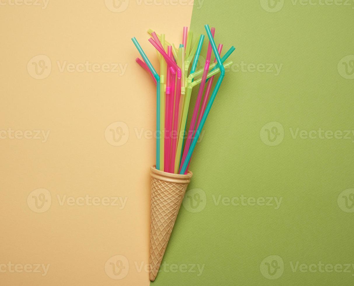 stack of plastic multi-colored cocktail tubes on a green background photo