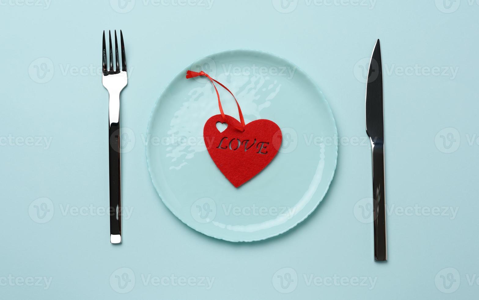red heart lies in a blue round ceramic plate photo