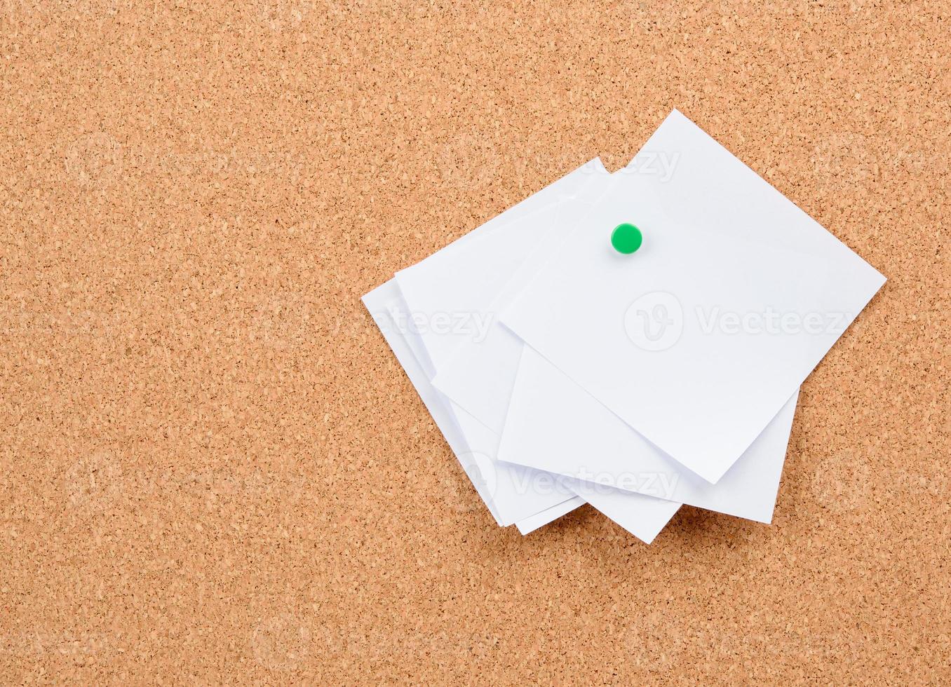 pedazos de papel en blanco cuadrados blancos fijados en un tablero de corcho foto