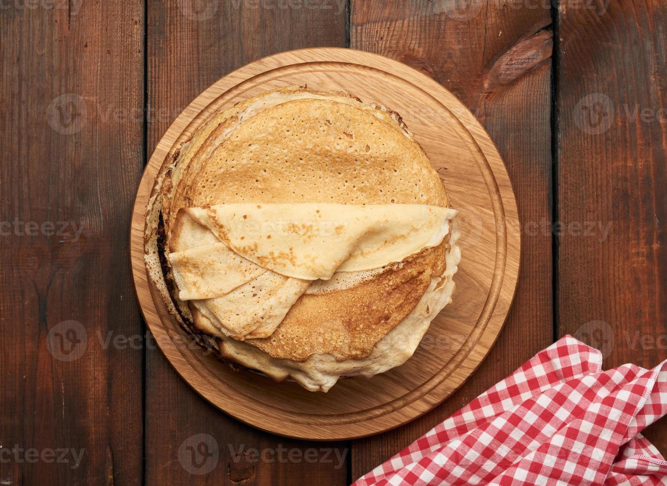 fried round pancakes on a wooden board, brown table photo