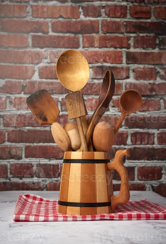varias cucharas y utensilios de cocina de madera en un bol sobre la mesa foto