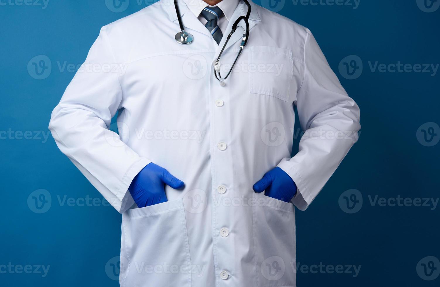 médico con bata blanca sobre fondo azul, hombre con corbata foto