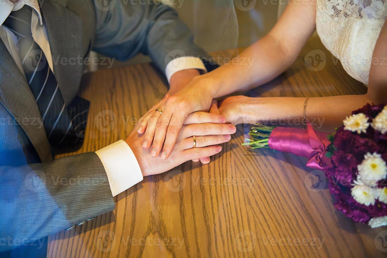 Hands newlyweds hold and sit in a cafe photo