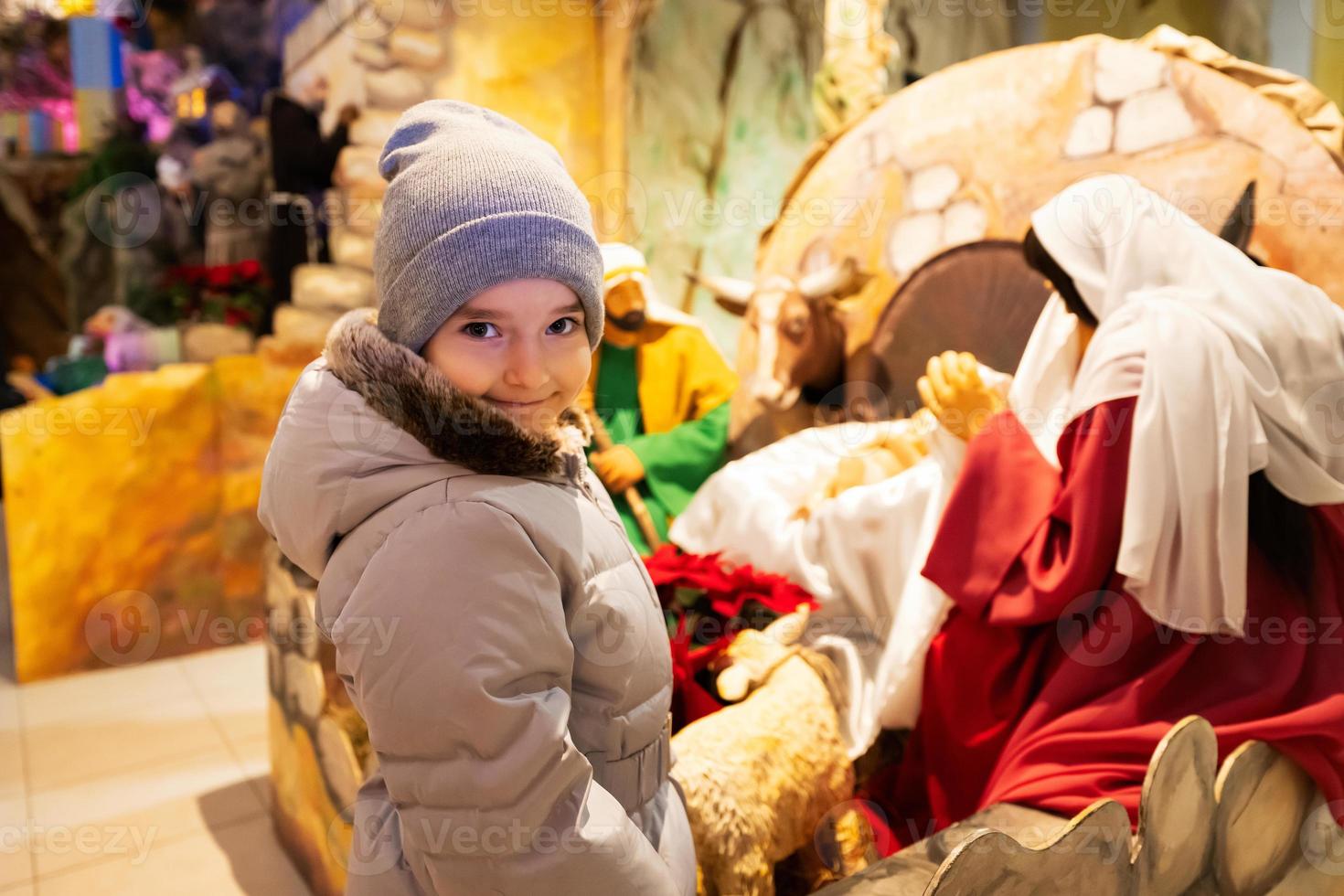 Christmas nativity crib scene in church. Baby girl against stable with baby Jesus in a manger, Mary and Joseph. photo
