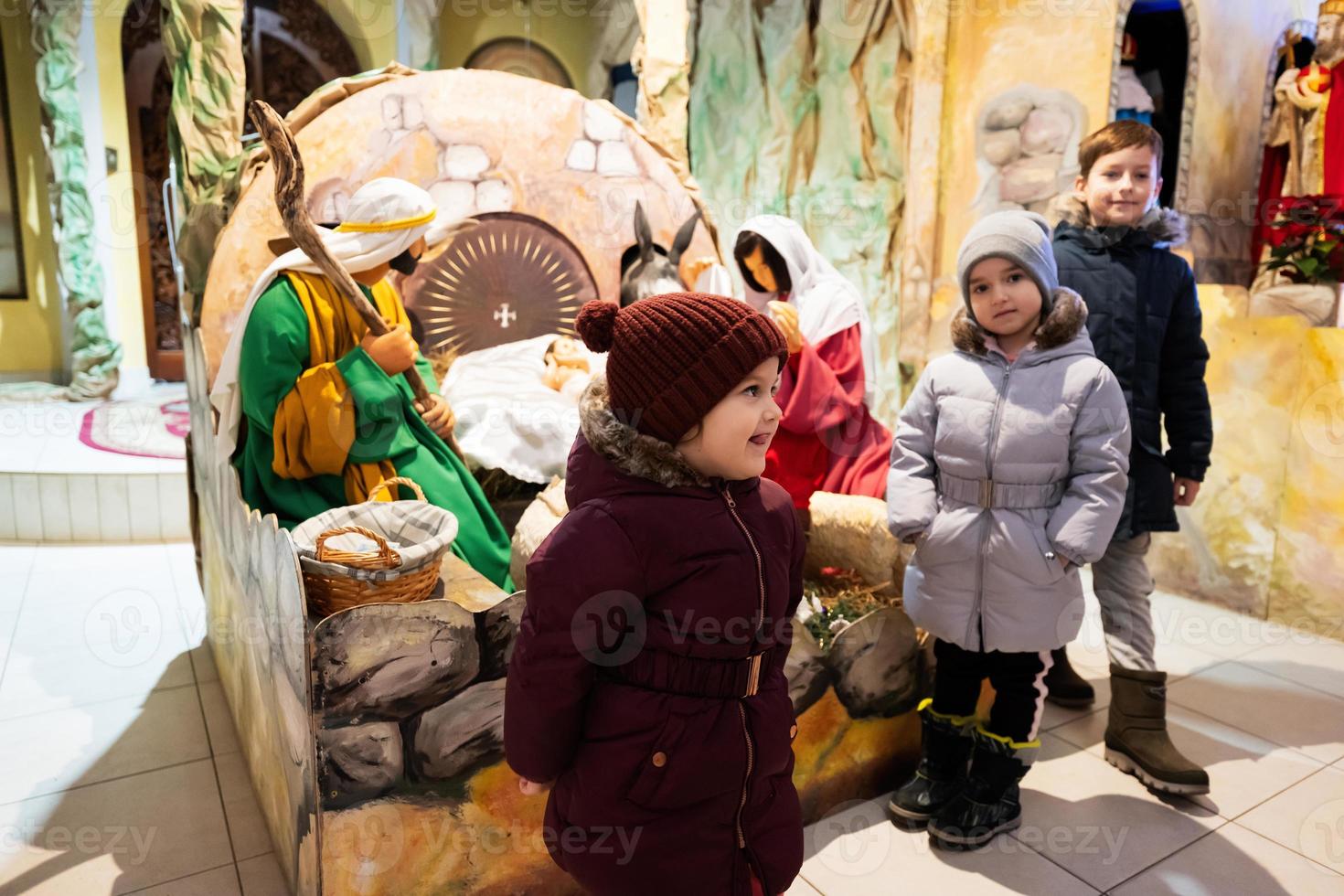 Christmas nativity crib scene in church. Kids visit stable with baby Jesus in a manger, Mary and Joseph. photo