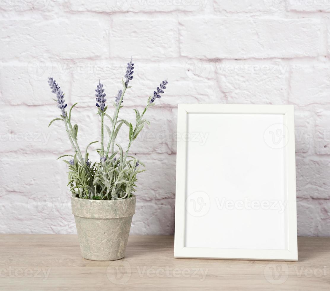 empty white wood frame and lavender pot on shelf, white brick wall photo