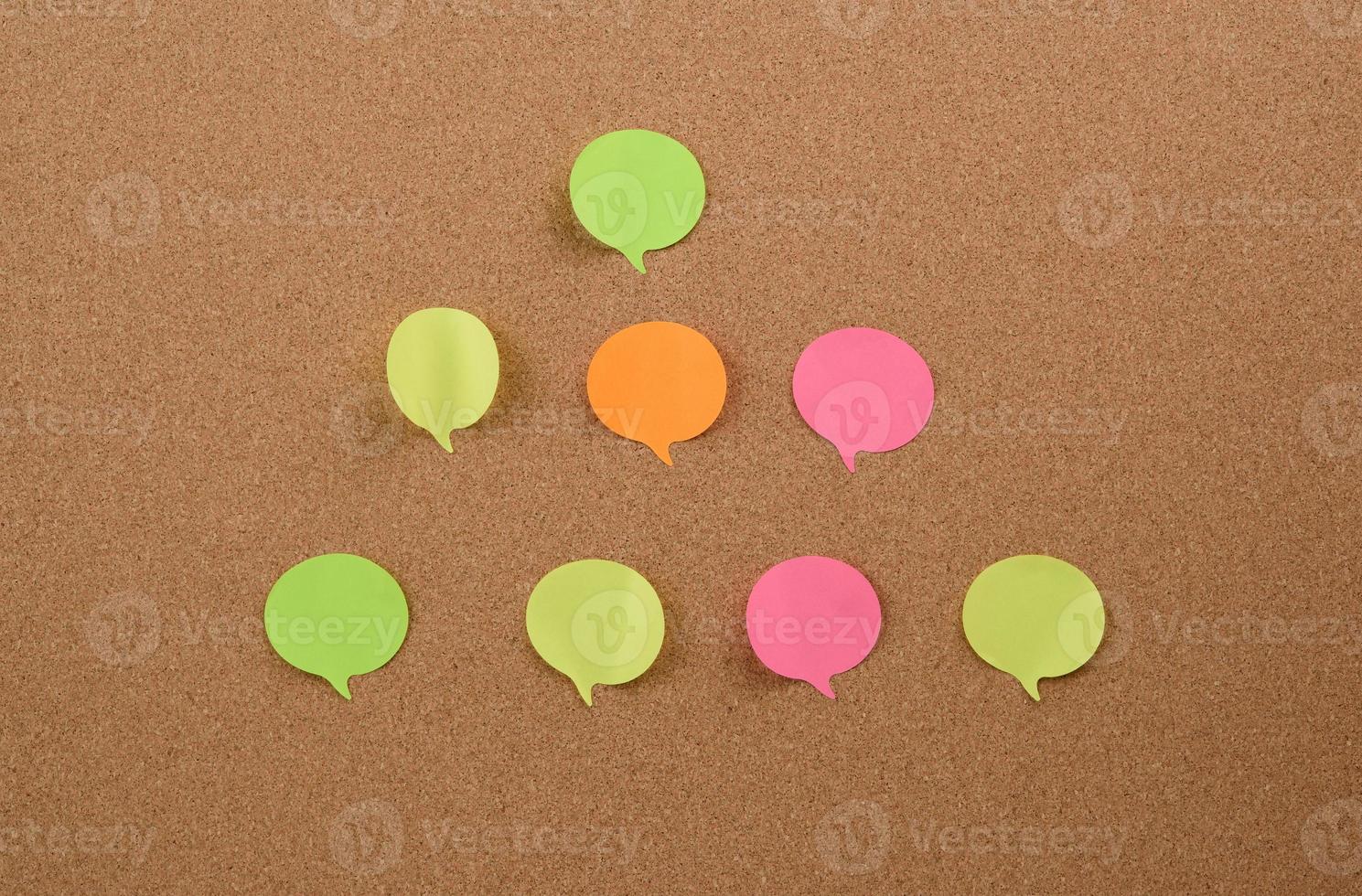 multicolored round sticks are glued to the brown cork board photo