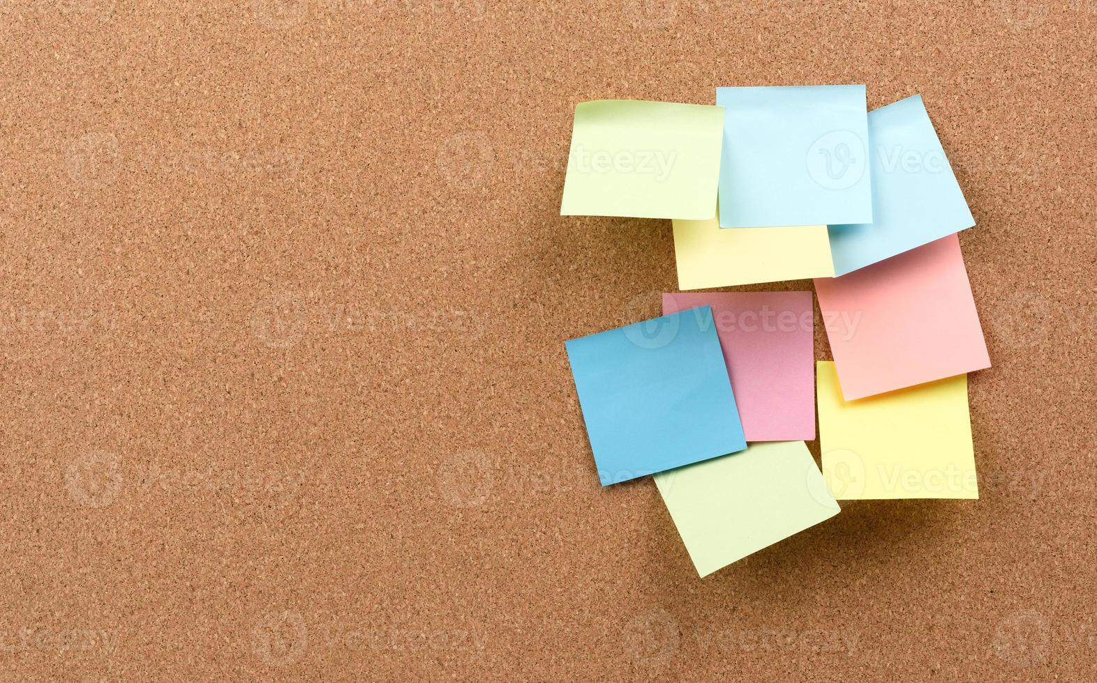 multicolored square sticks are glued to the brown cork texture photo