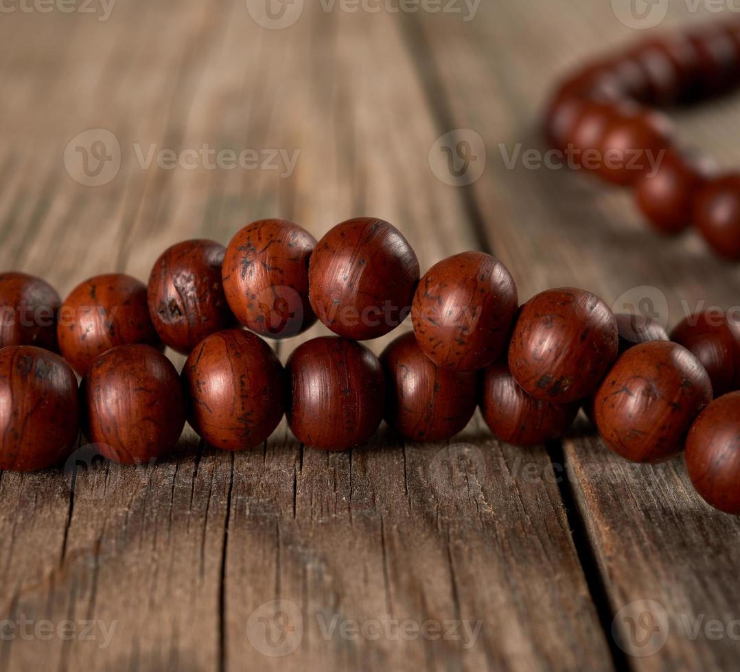 brown wooden prayer rosary on a wooden table photo