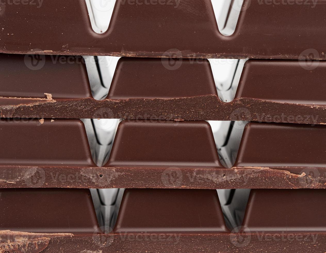 stack of pieces of black chocolate on a white background photo