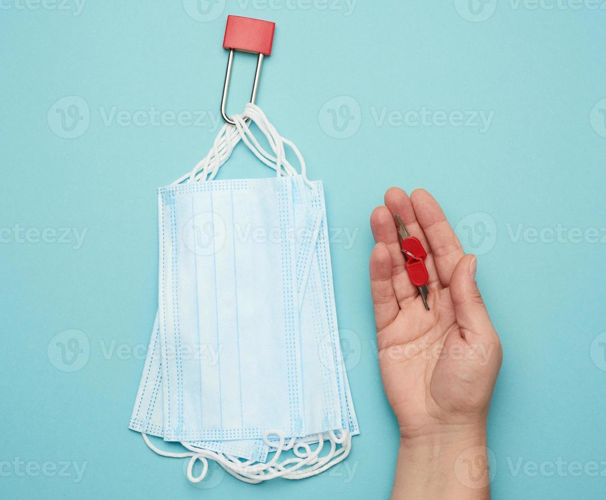 disposable mask and a metal lock on a blue background photo