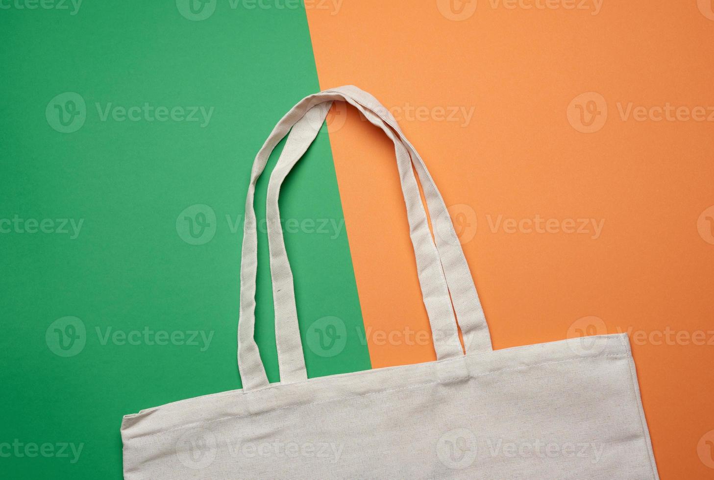 empty white textile reusable cotton shopping bag on a green background photo