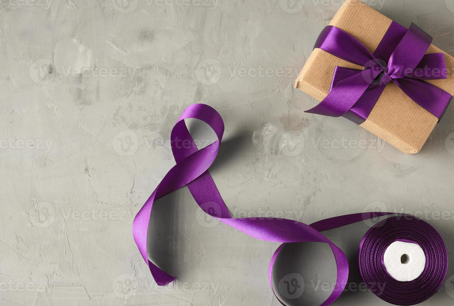 gift wrapped in brown kraft paper and tied with a purple silk bow photo