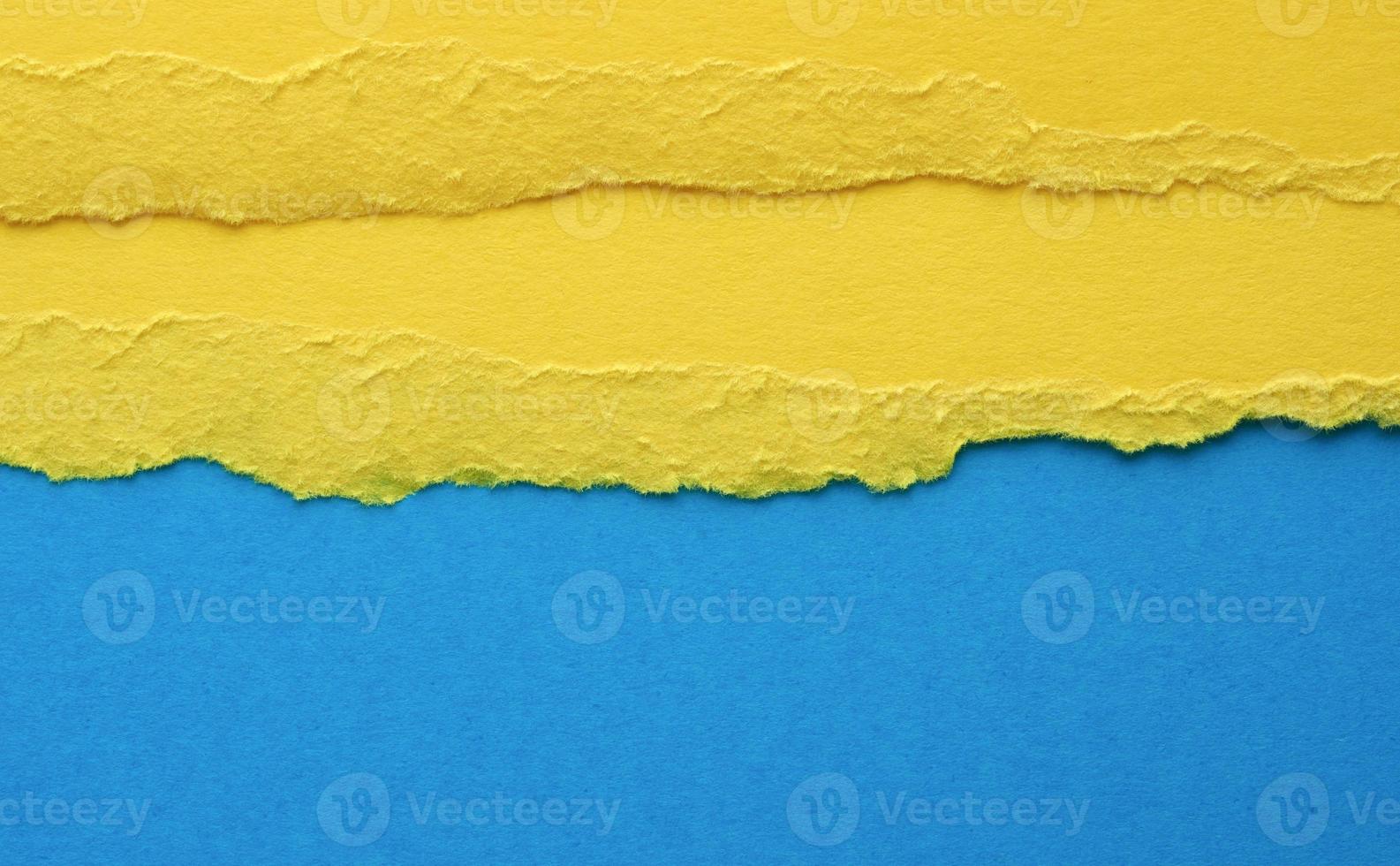 background with torn edges of yellow paper, blue backdrop, close up photo