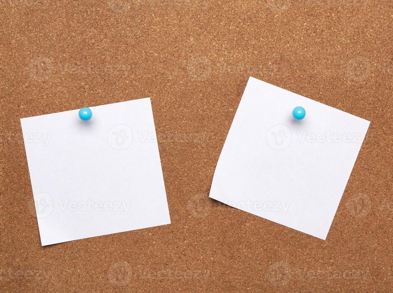 blank square white sheet of paper attached with blue button on a brown background photo