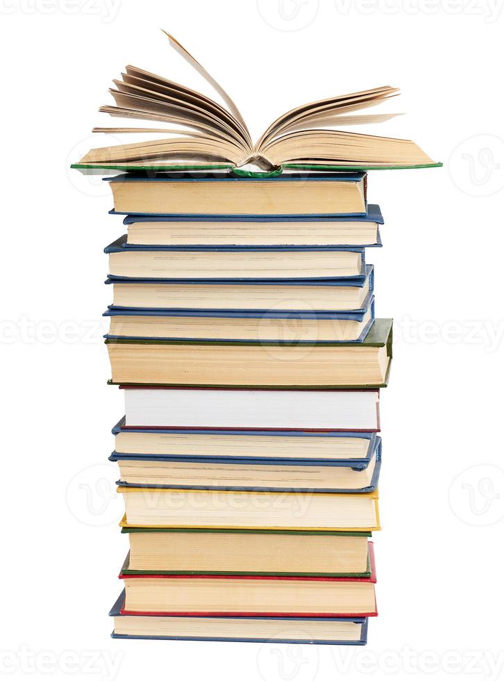 stack of various books, on top an open book, items are isolated on white background photo