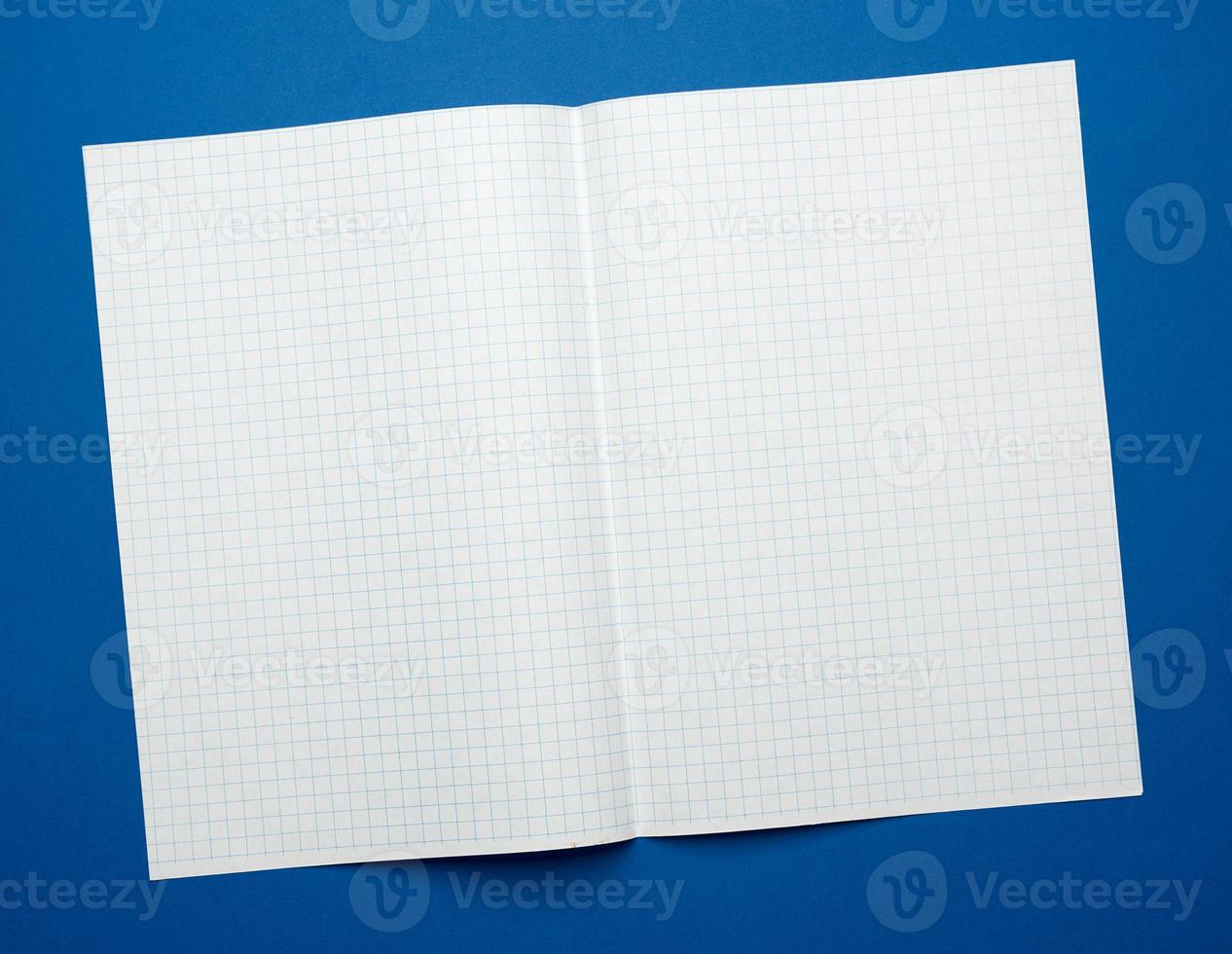 white sheet of paper in a cage from a school notebook on a blue background photo