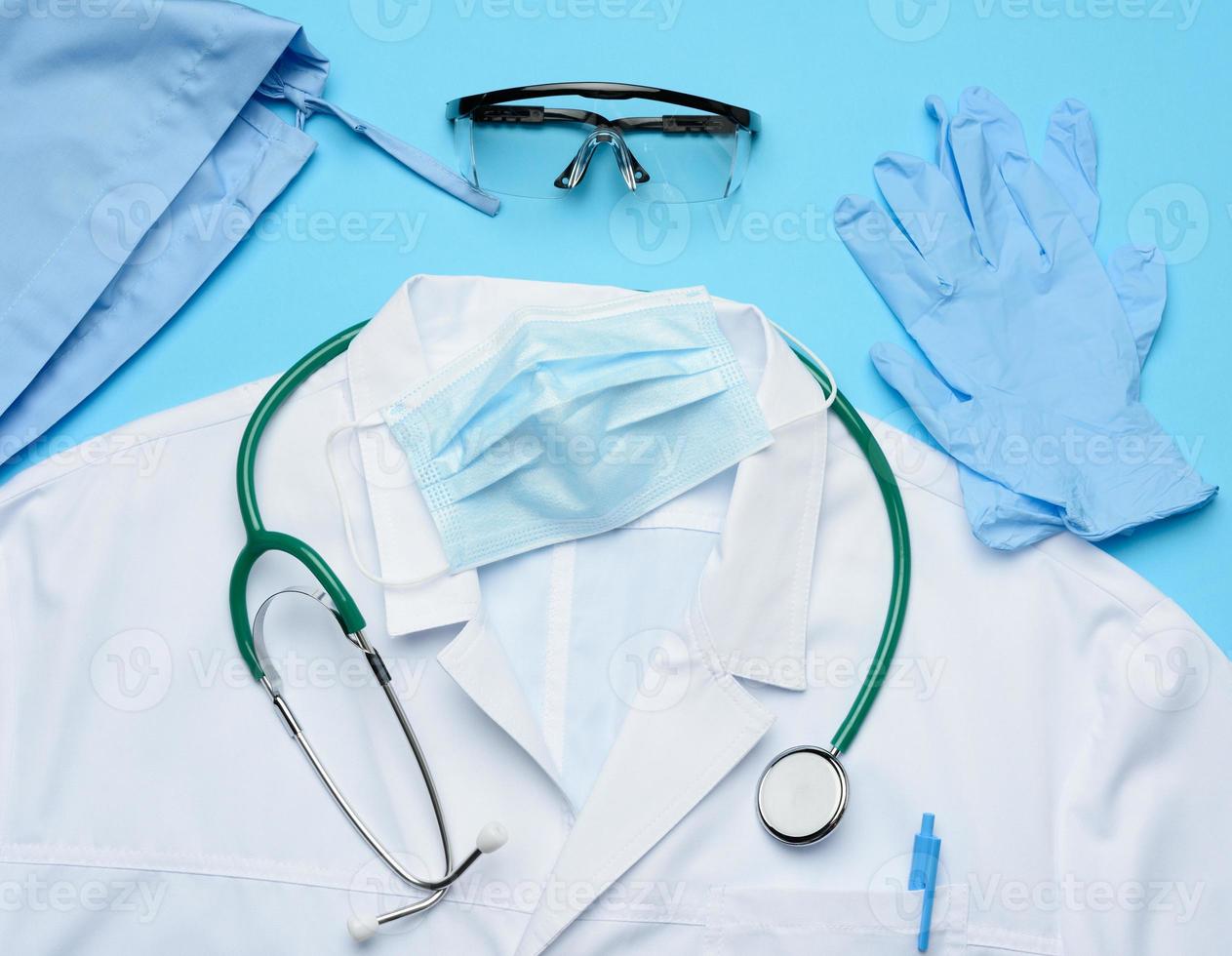 textile cap, white medical gown, disposable mask and protective plastic glasses photo