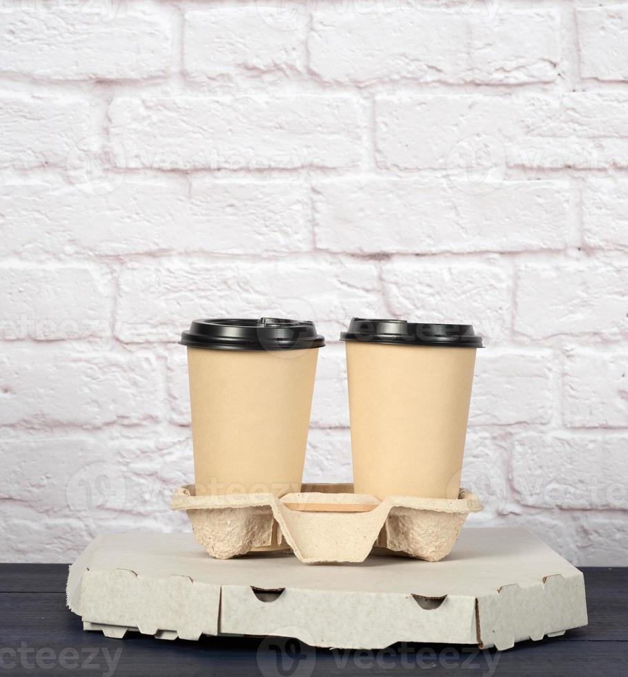 white cardboard box with pizza and disposable paper cups with coffee in holder photo