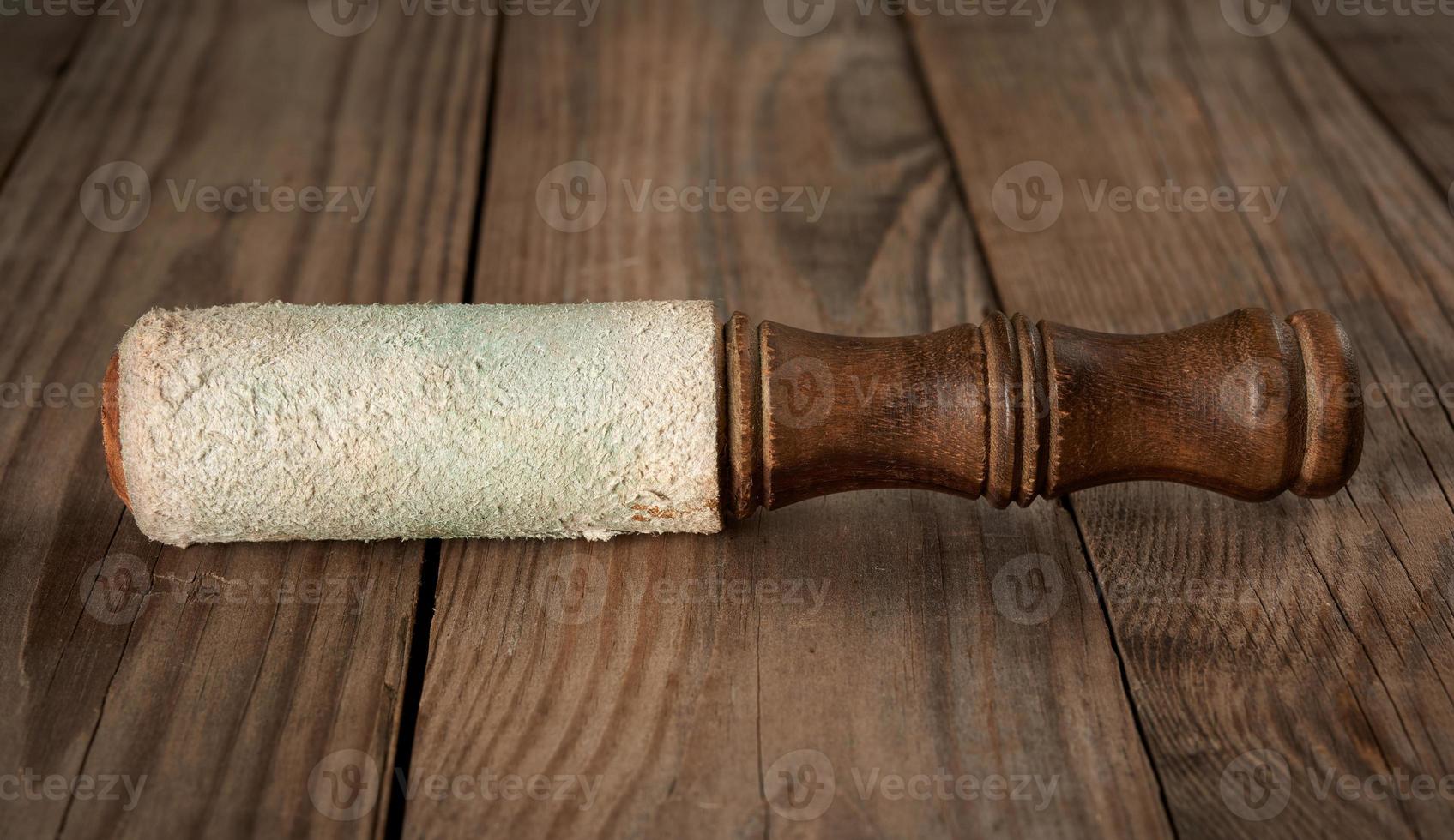 wooden clapper for singing bowls on a gray wooden background photo