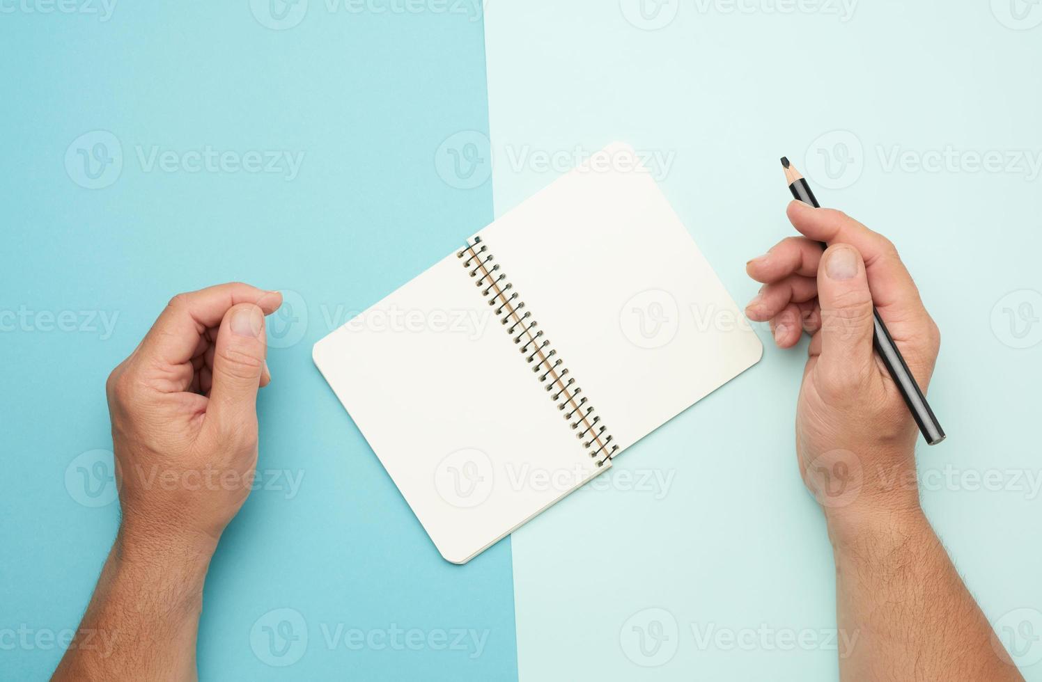 two male hands holding open notepad with empty white sheets photo