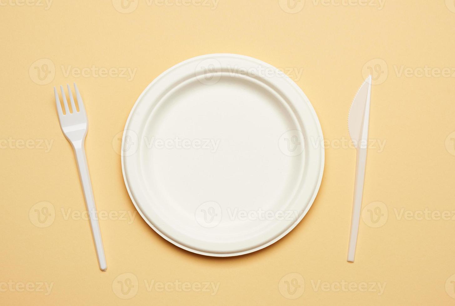 empty round brown disposable plate made from recycled materials  on a beige background photo