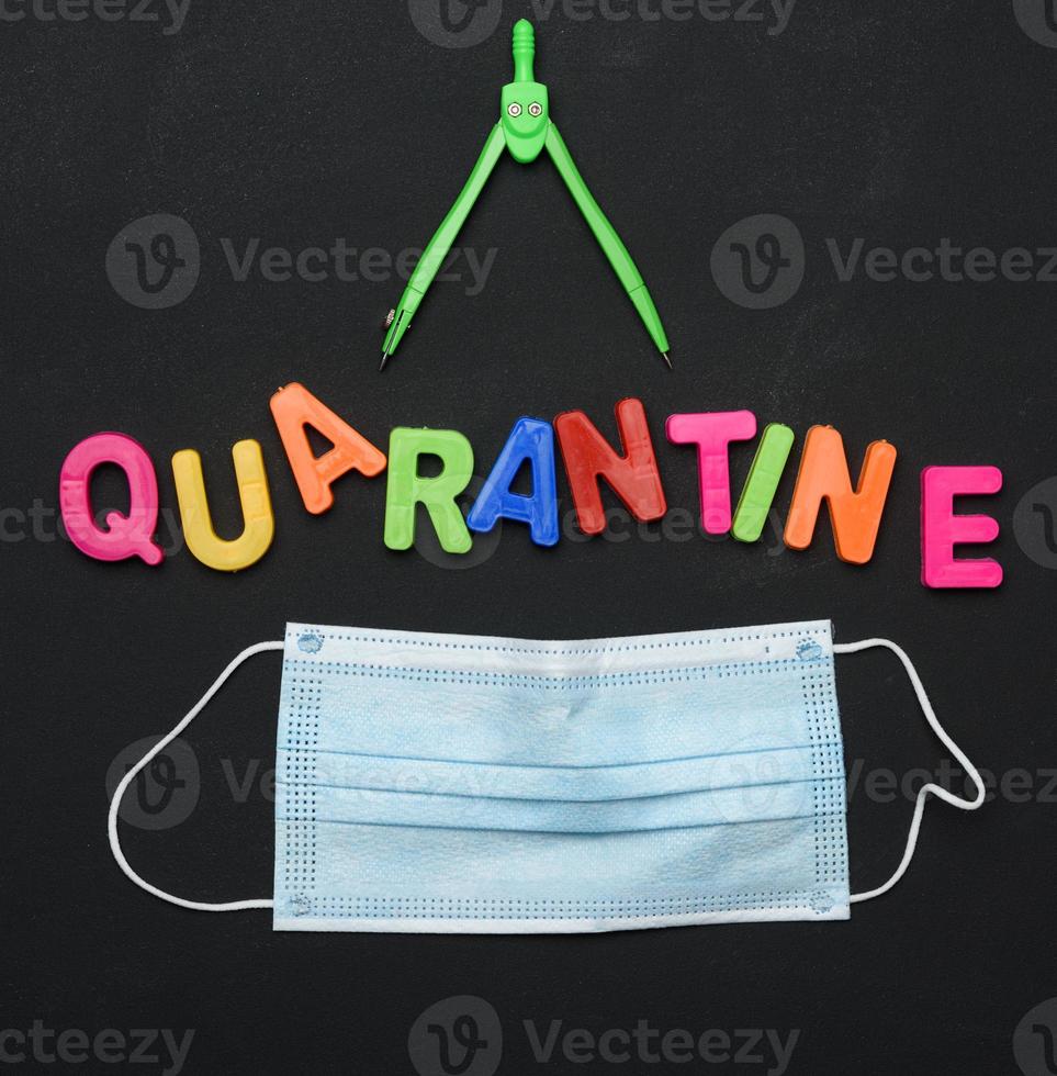 inscription quarantine from multicolored plastic letters and school supplies on black chalk board photo