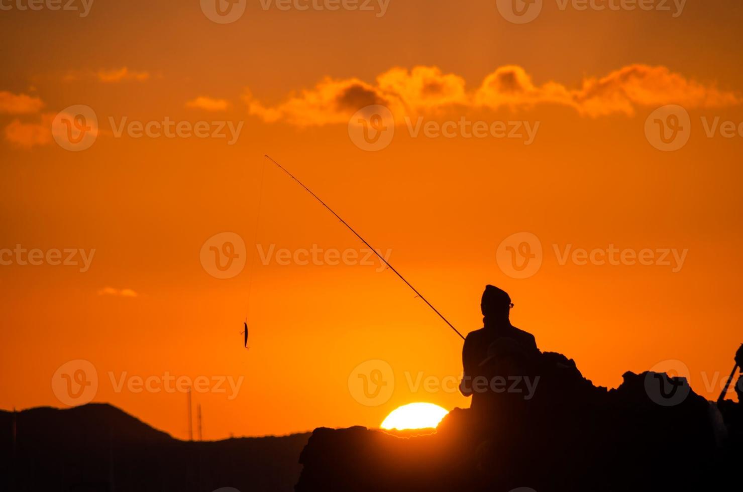 carrete de pesca sobre la puesta de sol foto