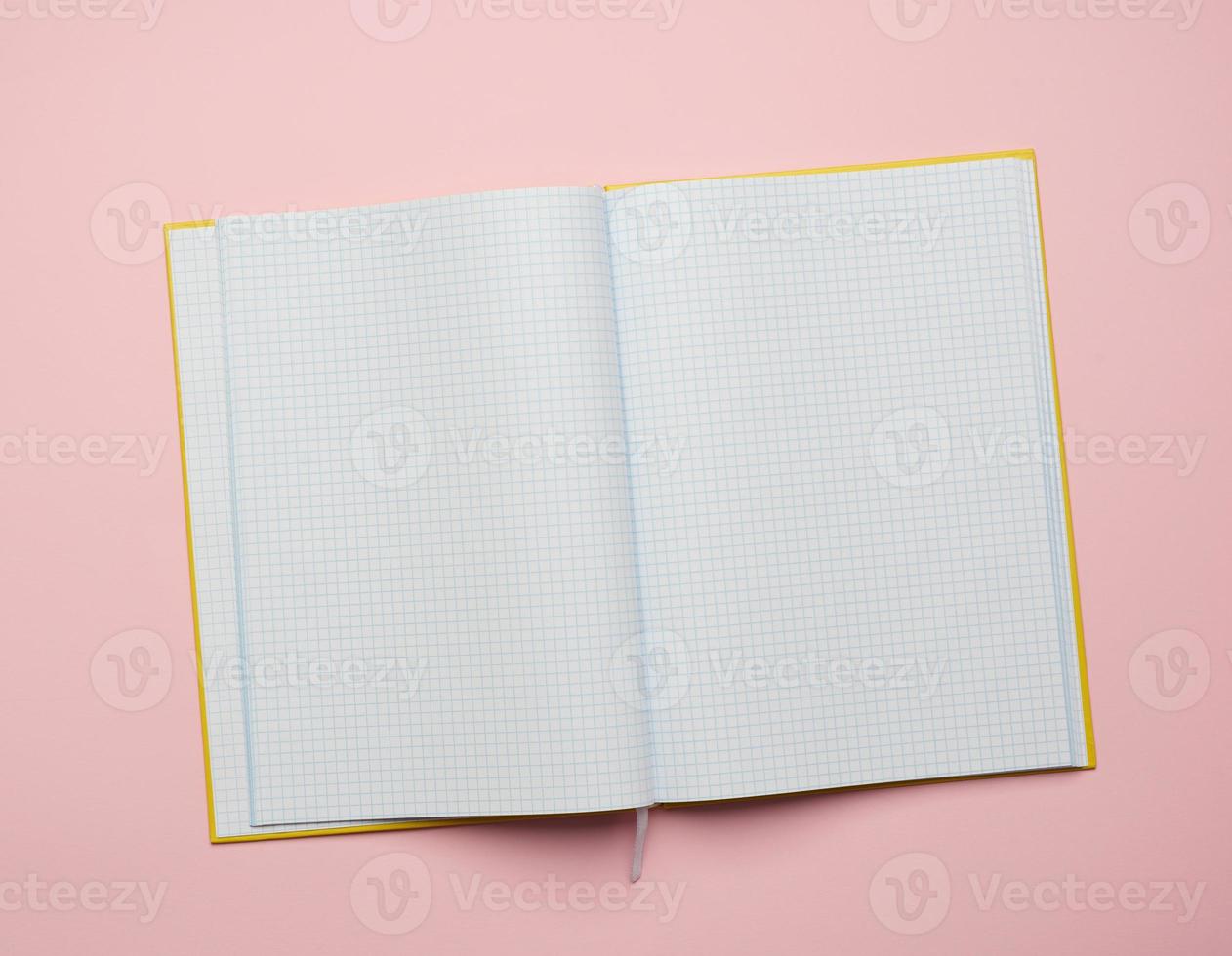 open notepad with empty white sheets on a pink background photo
