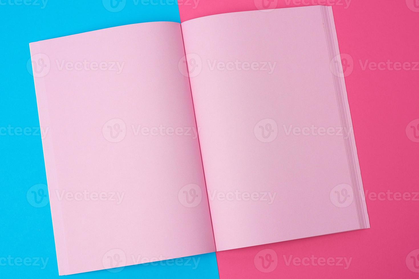 open notebook with blank pink pages on a blue background photo