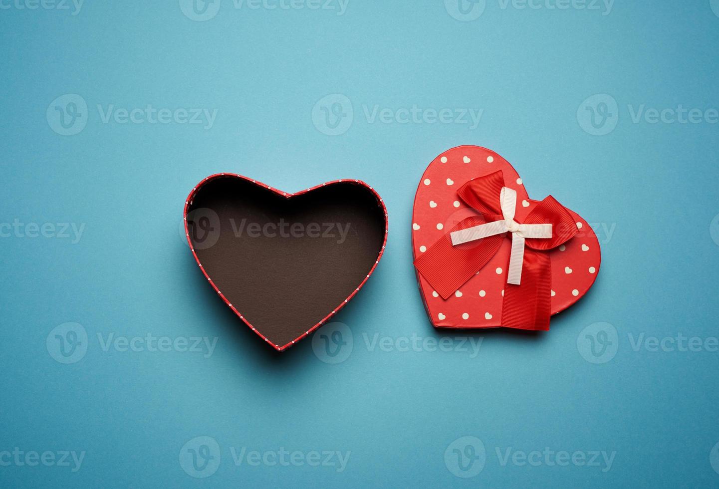 open empty red cardboard box in the form of a heart on a light blue background photo