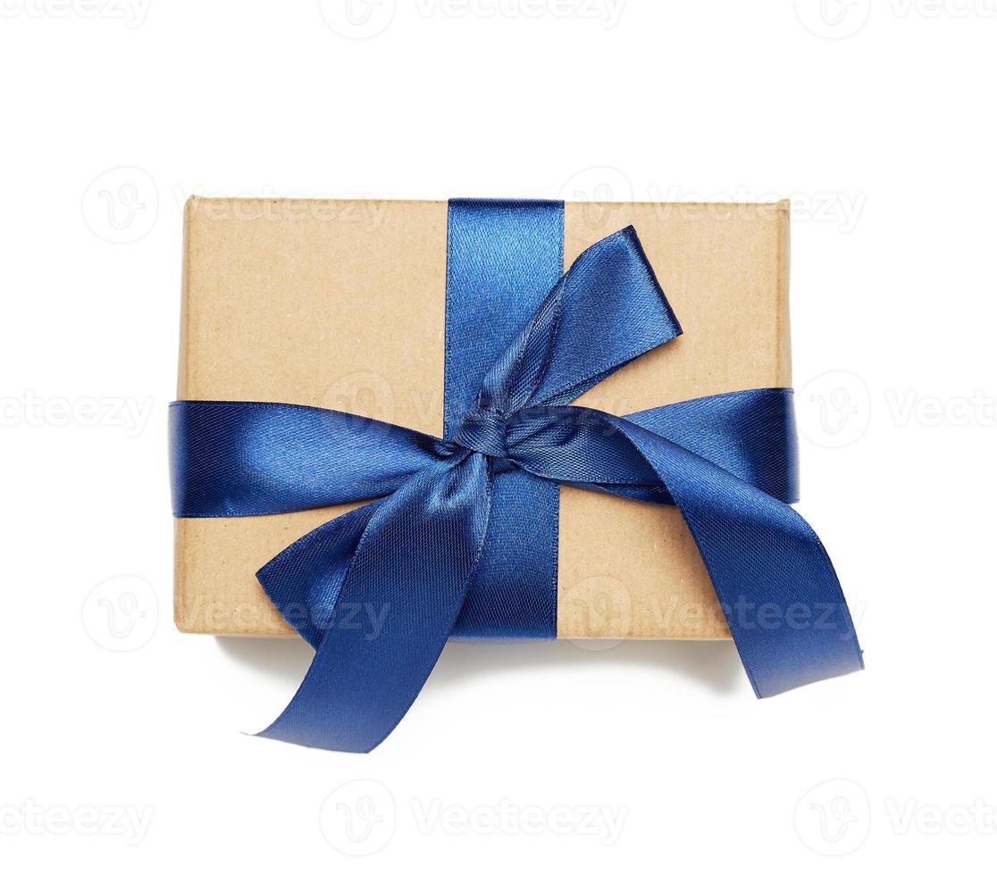 rectangular box wrapped in brown paper and tied with silk ribbon with a bow photo