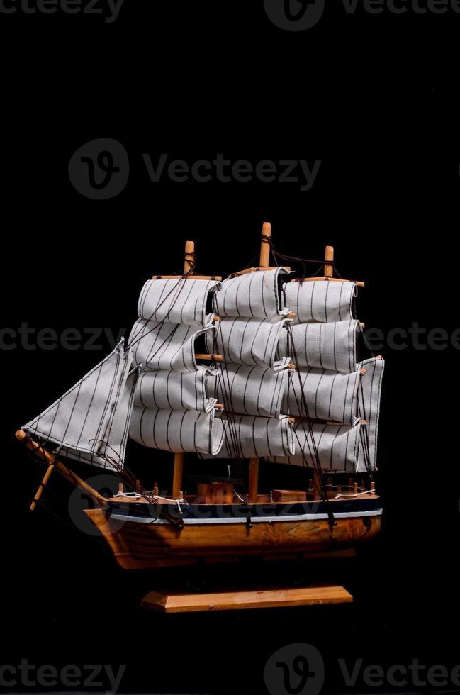 Miniature ship on black background photo