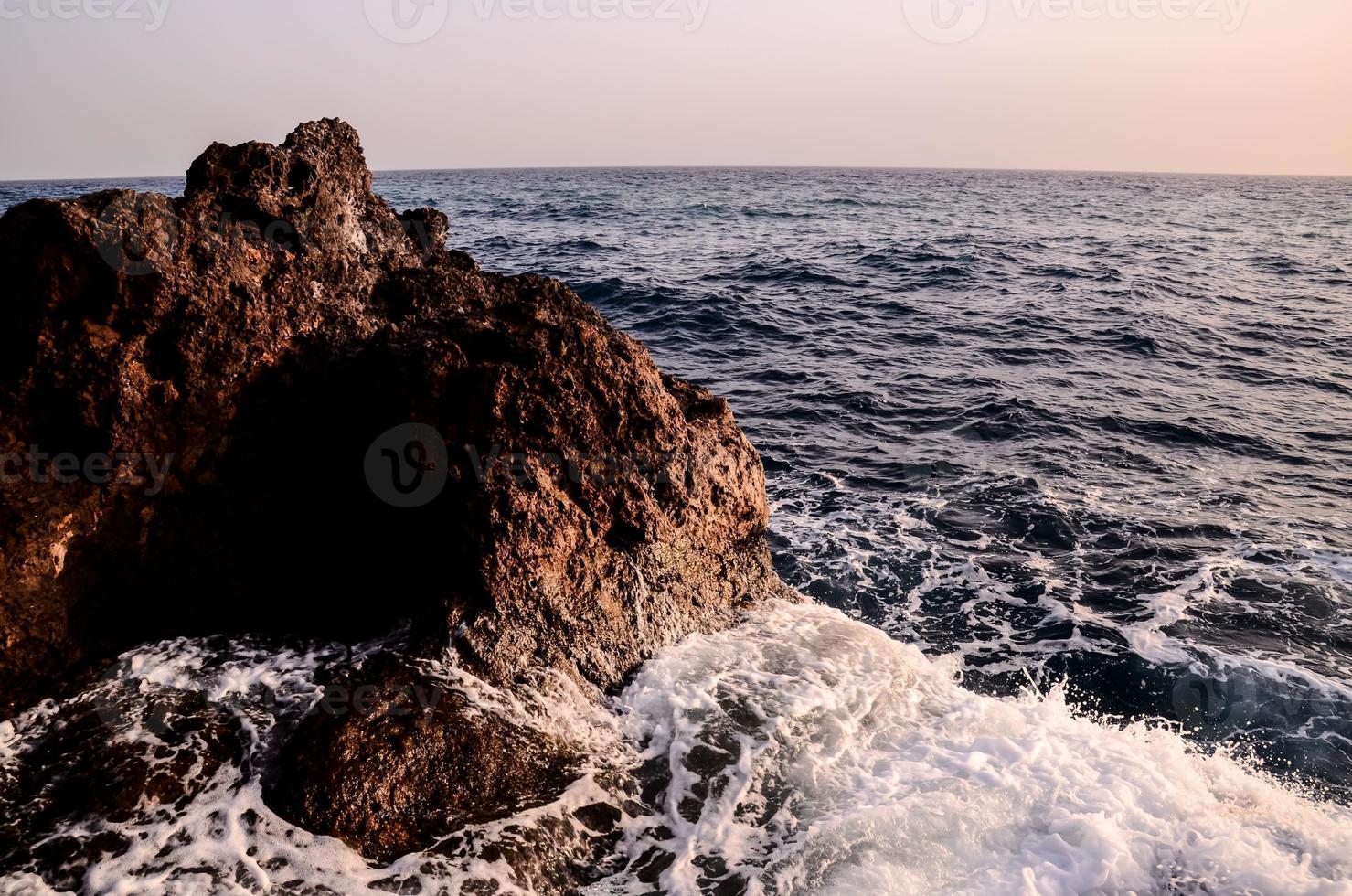 Sea waves hitting rocks photo