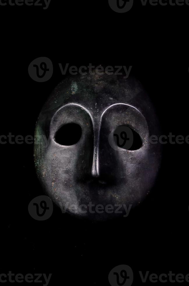 Metal mask on black background photo