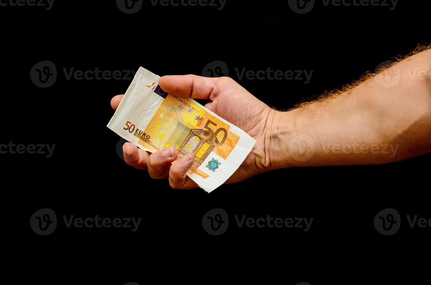 mano sujetando dinero en efectivo sobre fondo negro foto