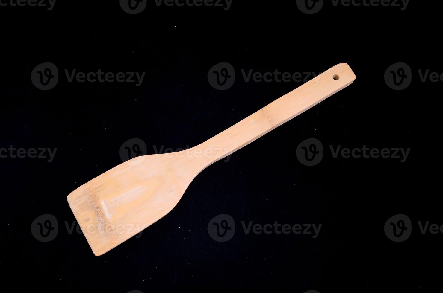 Wooden spoon on black background photo