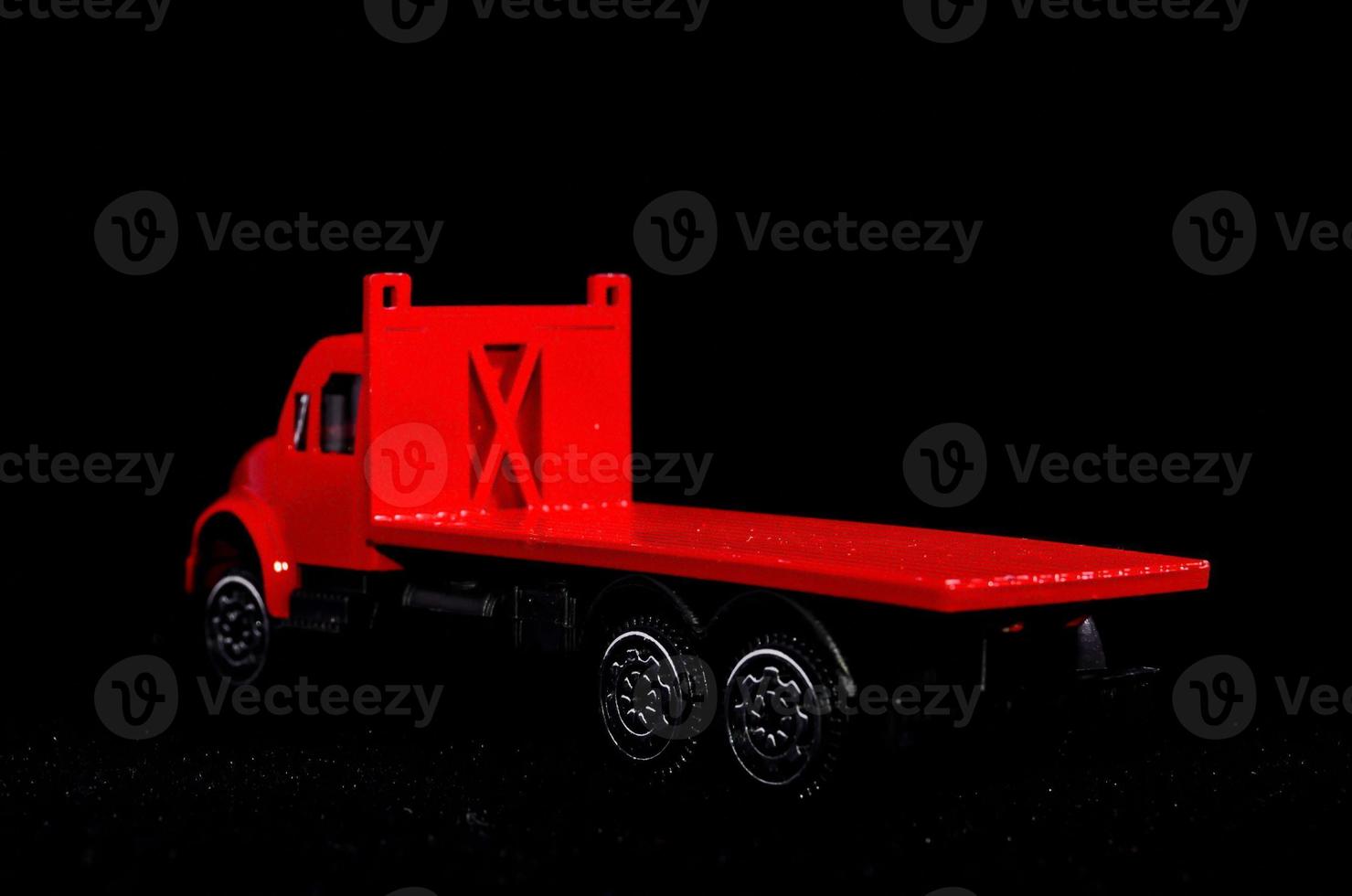 Red toy truck on black background photo