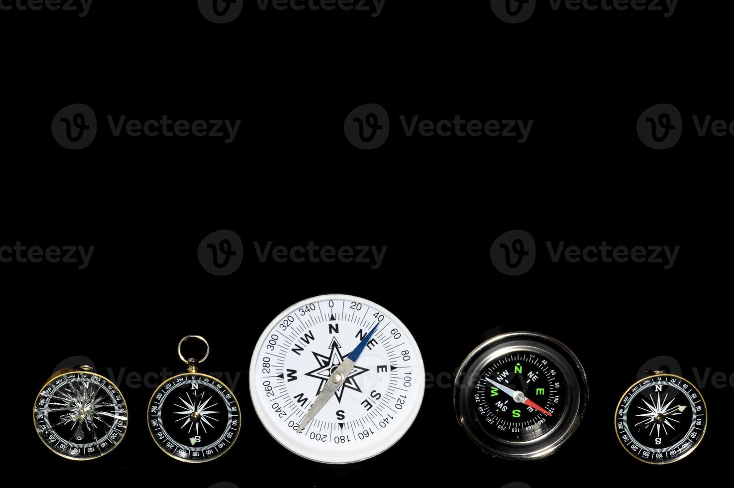 Analog compasses on black background photo