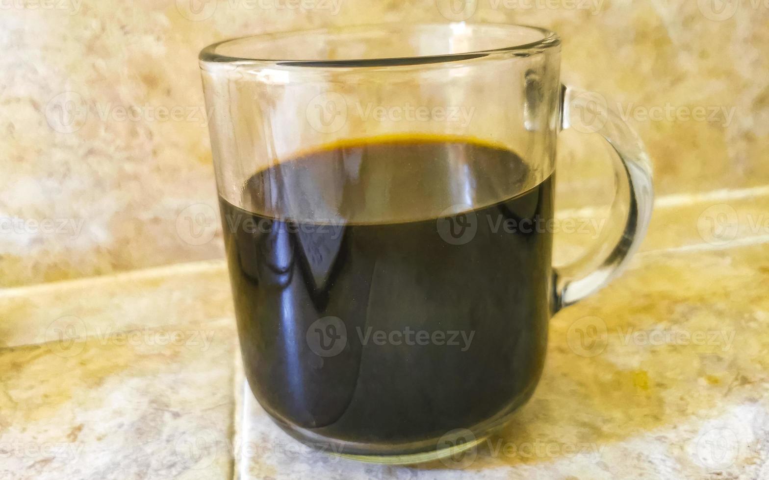 Glass cup of black coffee from Mexico on wooden background. photo